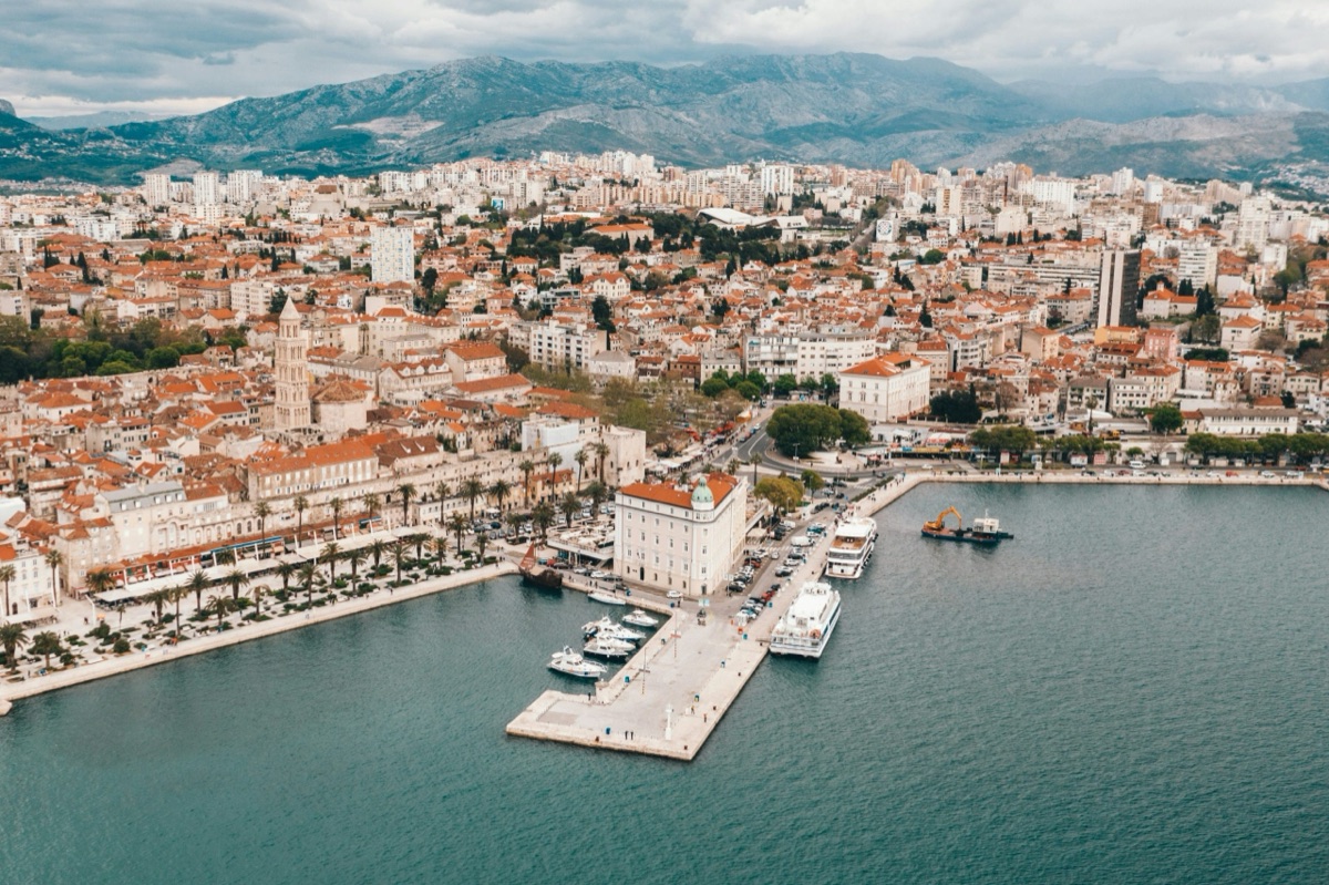 Dalmatian ferry harbor at sunset with Jadrolinija ferry, marina boats, and coastal town, Croatia